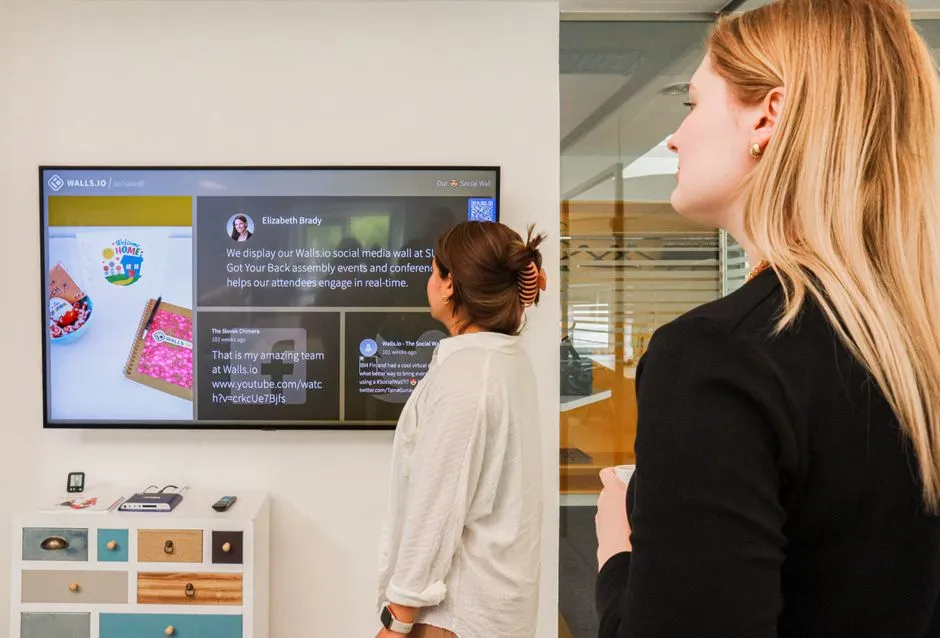 a digital recognition wall showing peer-to-peer shoutouts and photos