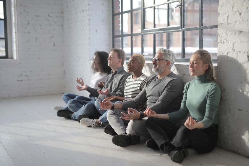 team practicing mindfulness during virtual meeting - wellbeing activities for virtual team meetings