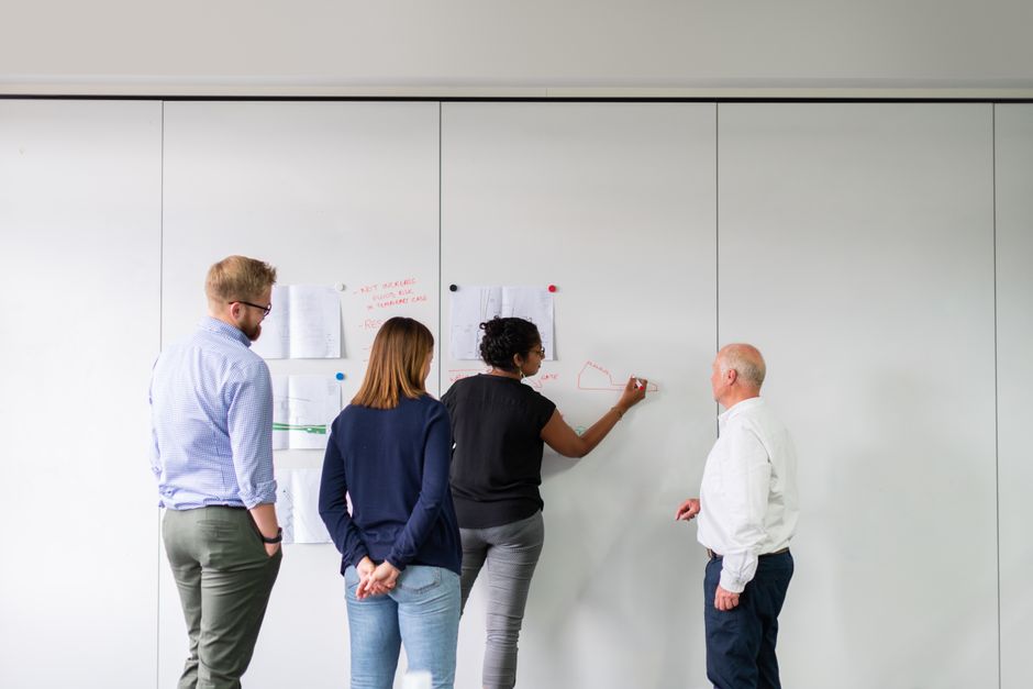 Team brainstorming CSR ideas on a whiteboard - Small business CSR