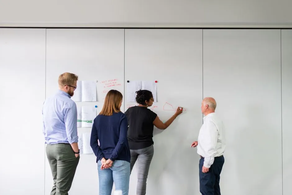 Team brainstorming CSR ideas on a whiteboard - Small business CSR