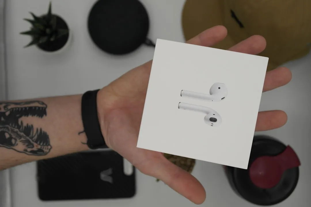 An employee unboxing a high-end tech gift like wireless earbuds - employee engagement gifts