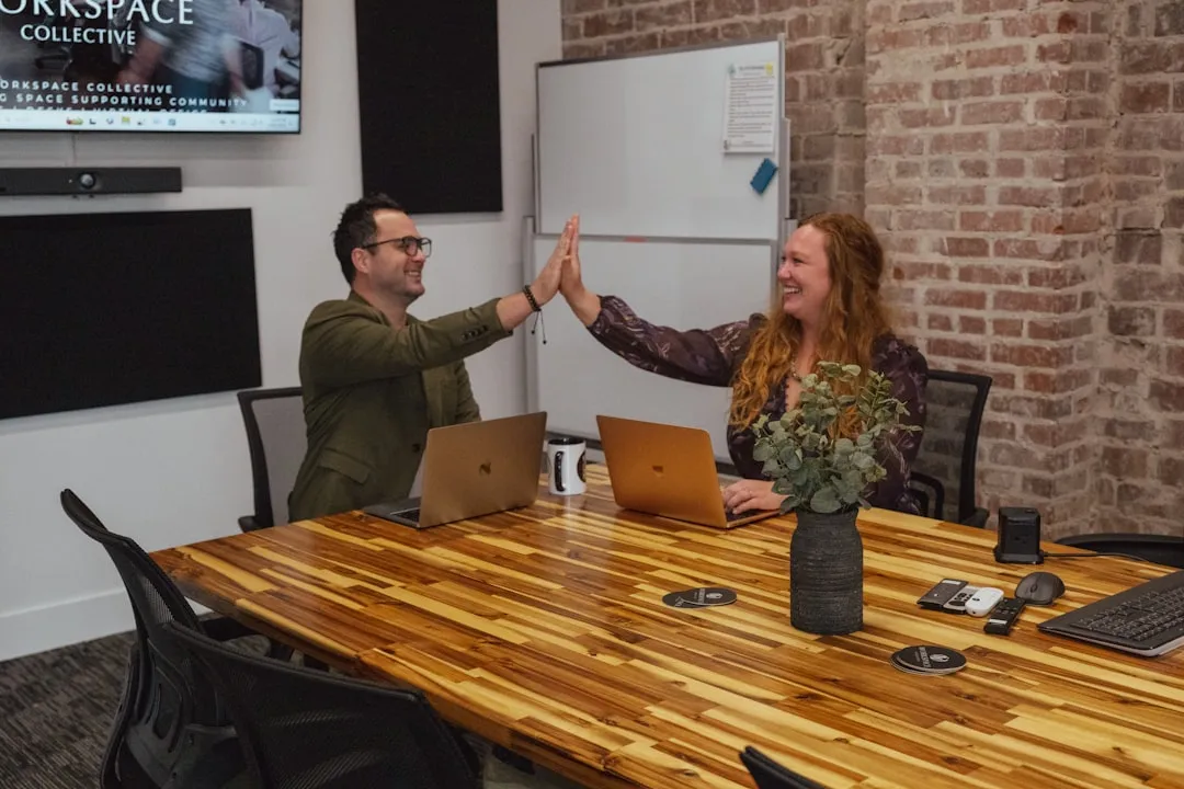 A manager giving a high-five to an employee in a positive, collaborative office environment - staff motivation techniques