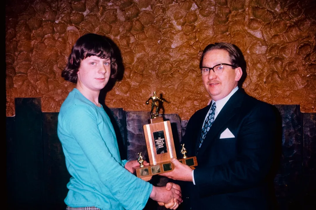 Manager presenting personalized award to a smiling employee - modern management practices such as employee management